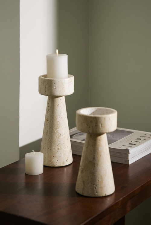 Castiçais de base cónica em tom creme sobre mesa escura